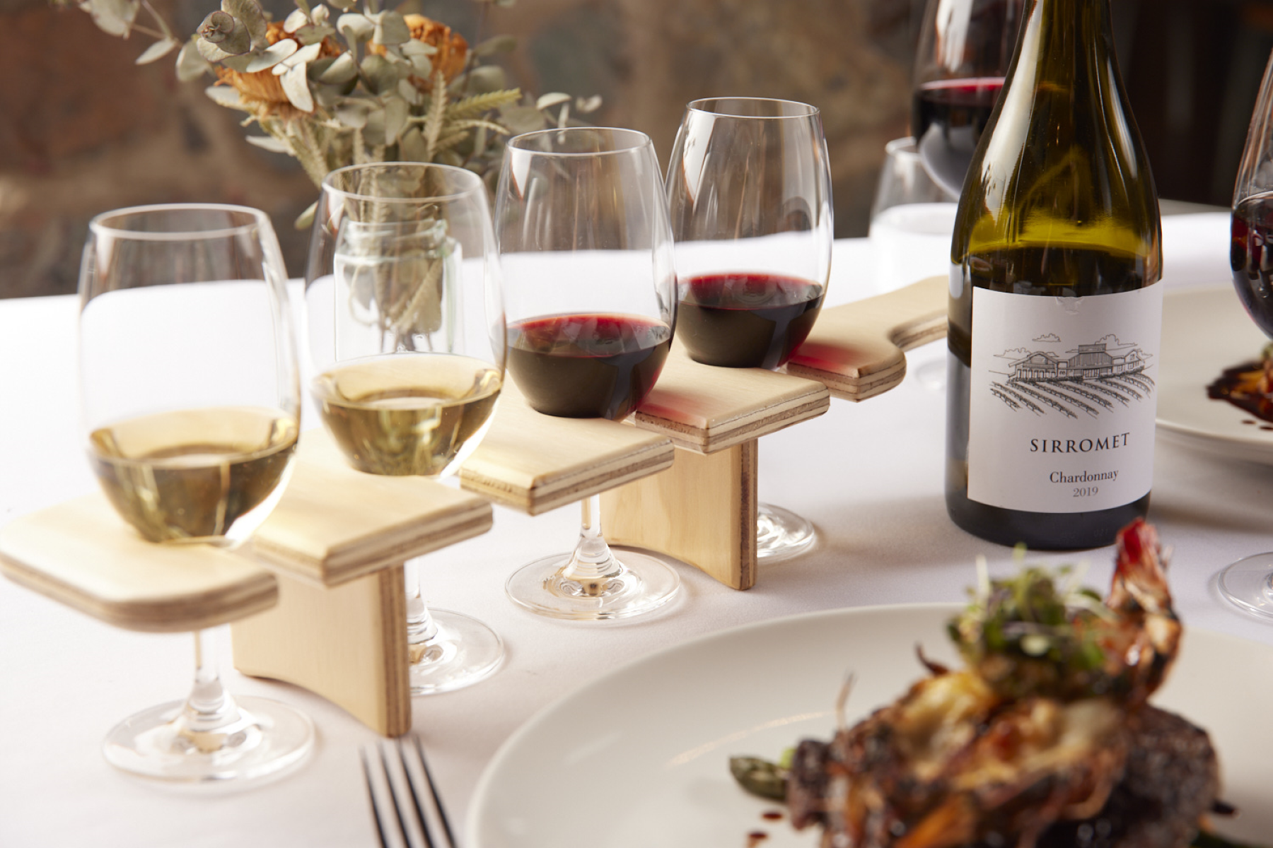 Wine glasses with wine and wine bottle on table with food